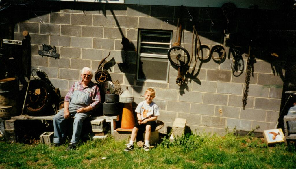 Grandfather and grandson sitting outside antique shop in Knoxville Tennessee, three generations connected through rural family legacy