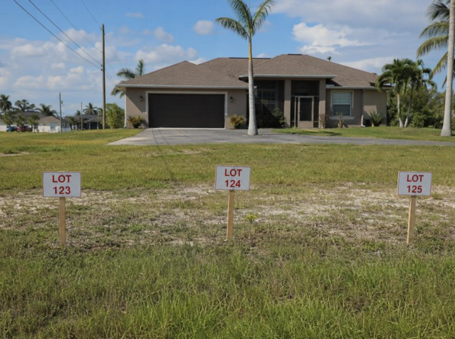 Cape Coral home spanning three lots with a property tax bill and future water and sewer expansion sign.